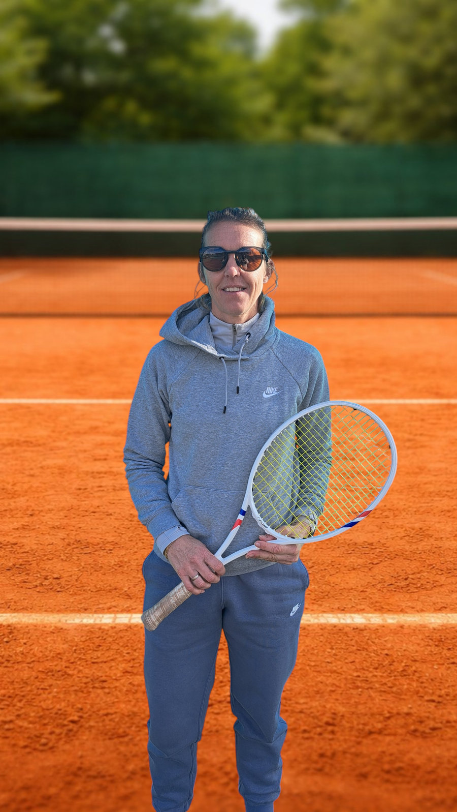 Mylie Gillet, monitrice de tennis à Antibes, raquette en main sur un court en terre battue